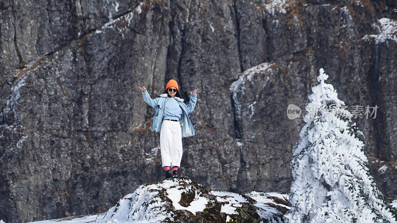 一个女人在寒冷的天气里穿行于白雪覆盖的山林之中