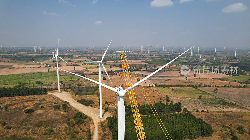 风力发电机的叶片通过起重机操作，安装风力发电机塔架的发动机，产生绿色能源，减少全球变暖和气候变化