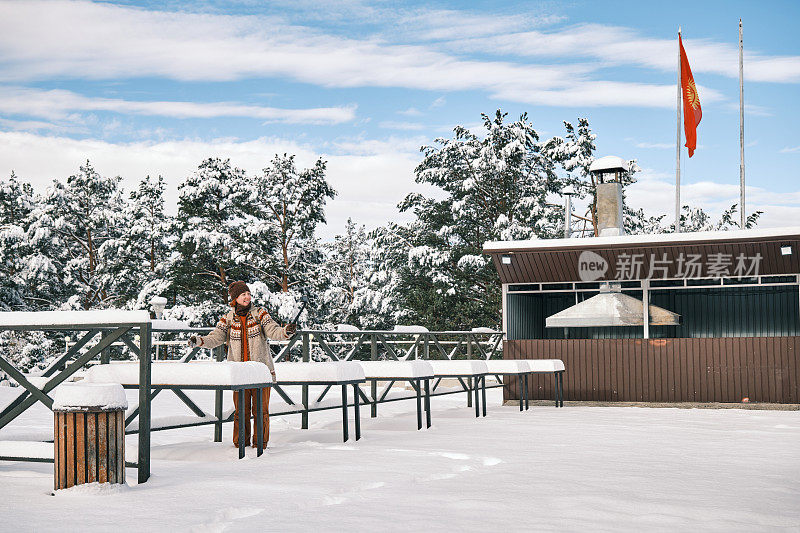 下雪后，一位女游客正试图清除咖啡桌上的雪