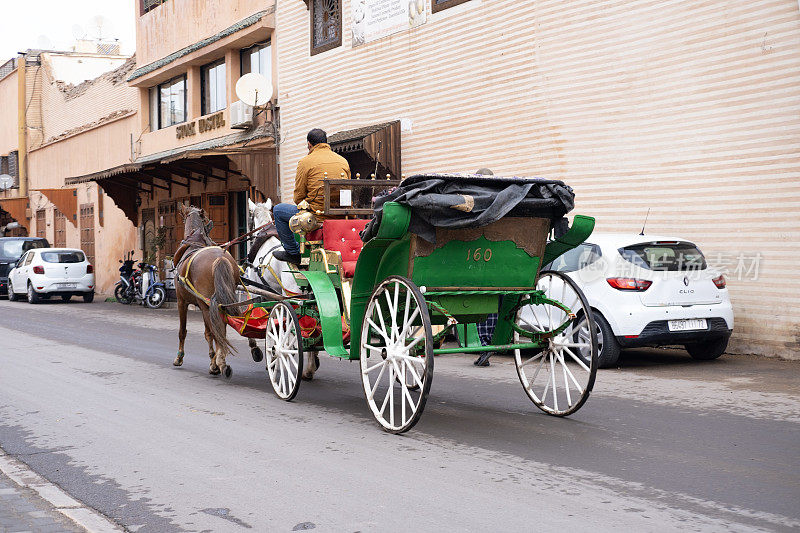 2024年1月3日，在摩洛哥首都马拉喀什，游客和当地人乘坐传统马车在迷宫般的城市街道上欢快地穿行