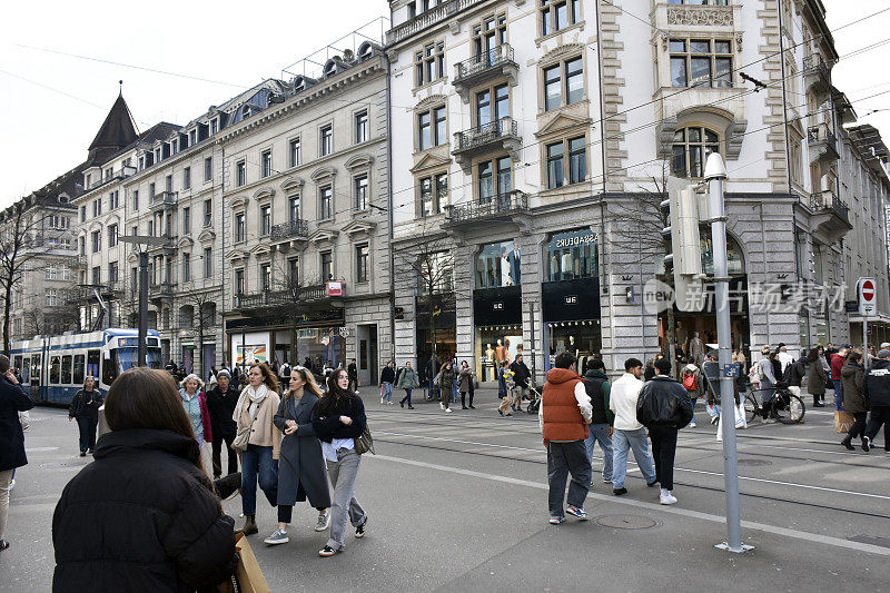 苏黎世商业区在瑞士欧洲，有轨电车，人们步行，零售商店视图