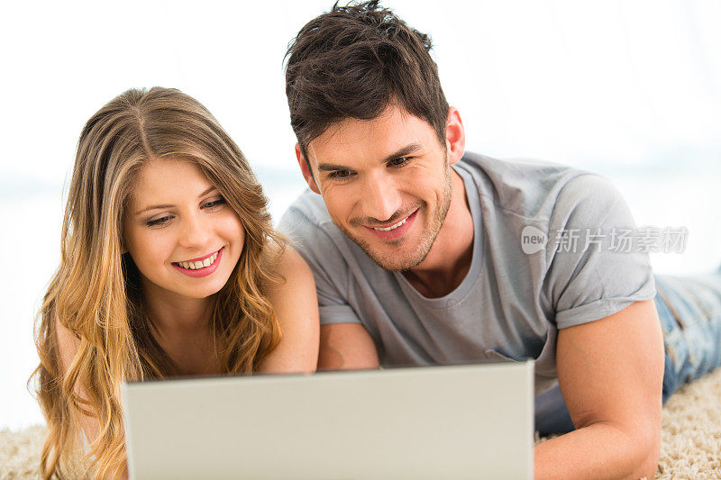 年轻夫妇在家用笔记本电脑工作