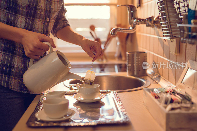一个面目全非的人在厨房泡茶。