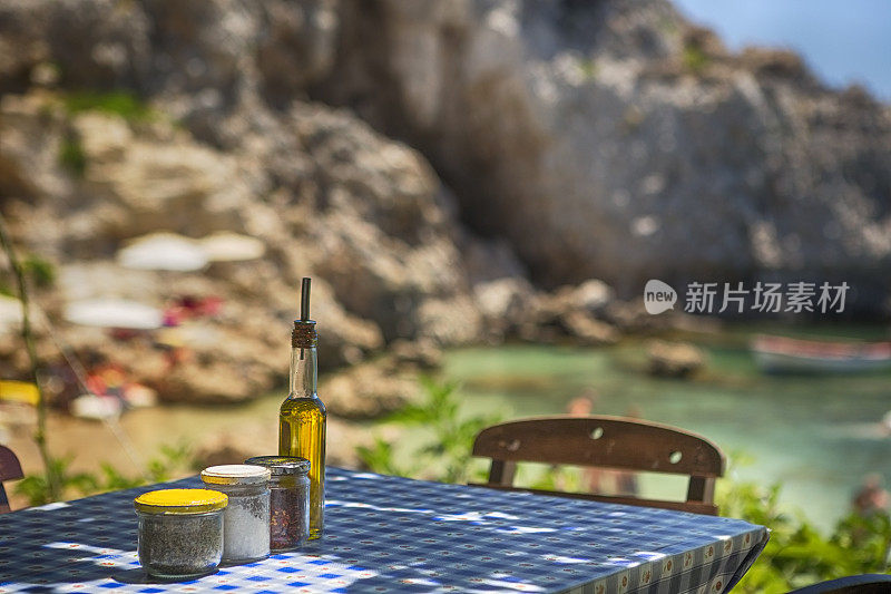 传统希腊酒馆的餐桌与海滩背景