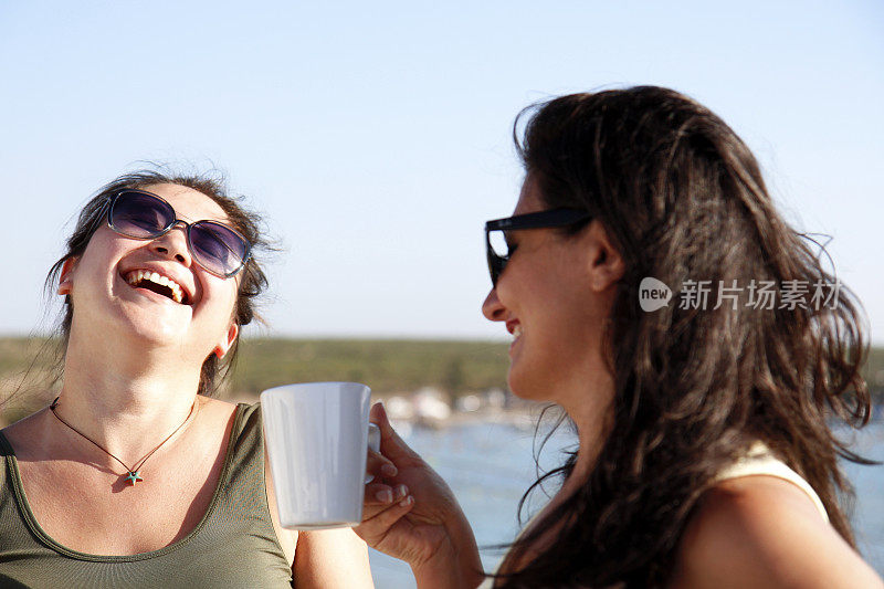两个女人微笑着喝着咖啡