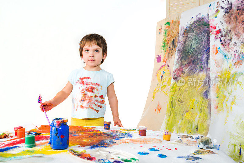 小孩子在纸墙上画颜料