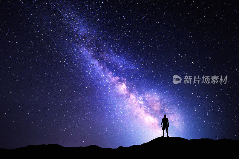 银河系。夜空和一个站立的人的剪影