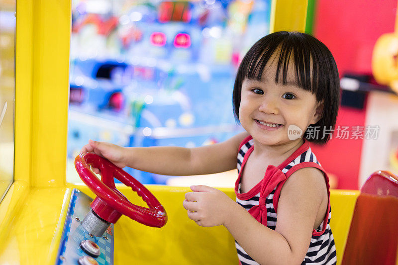 快乐的亚洲华人小女孩驾驶玩具巴士