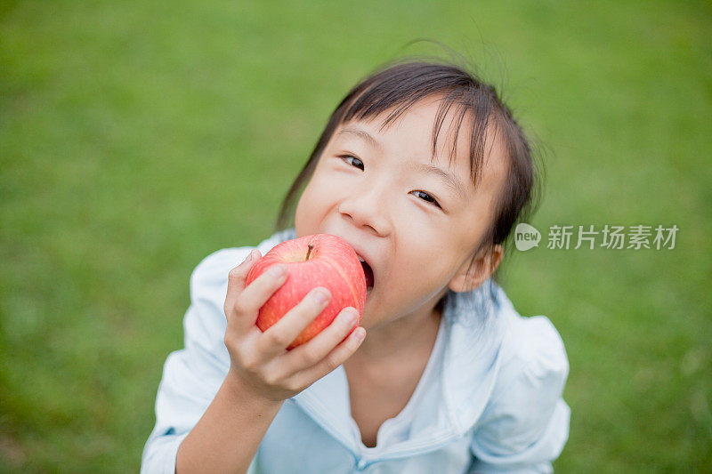 可爱的亚洲小女孩吃苹果