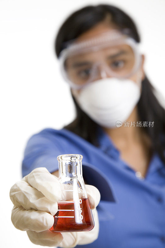 女化学学生在烧杯中拿出红色液体