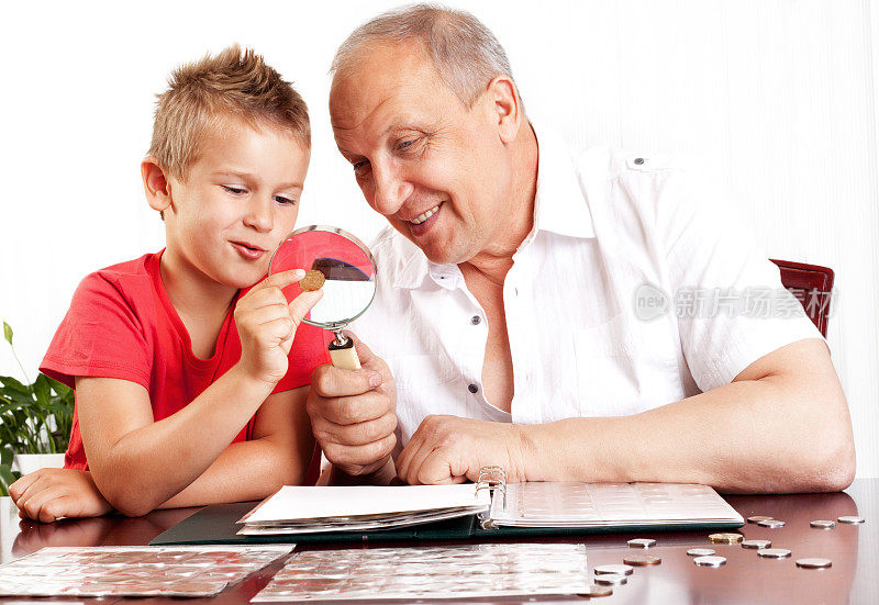 爷爷和孙子在看钱币收藏。