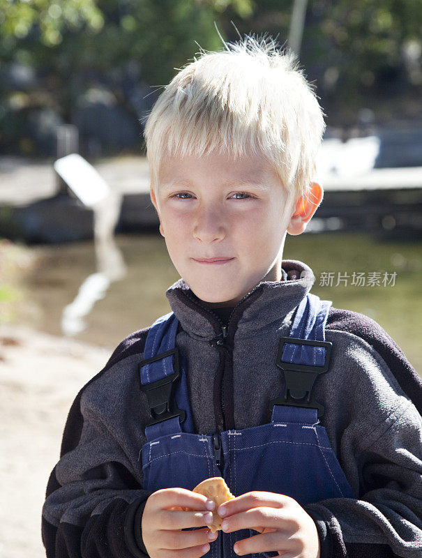 一个金发小男孩吃饼干的肖像