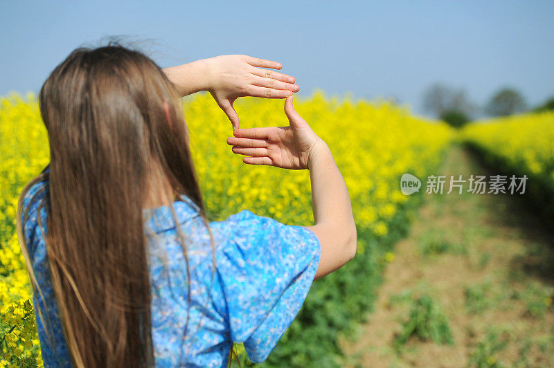 拿着自然构图框的女人。