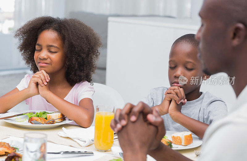 可爱的一家人在晚餐前祷告