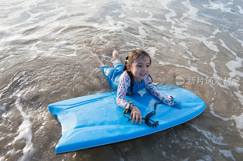 冲浪小女孩躺在冲浪板上