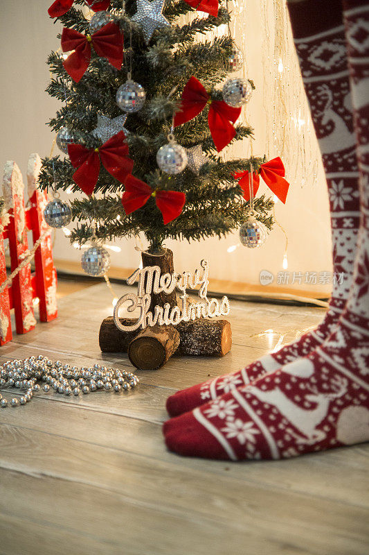 女人的腿在冬季的袜子由圣诞装饰