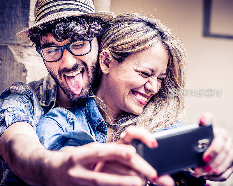 有趣的自拍，一对嬉皮夫妇用智能手机拍照