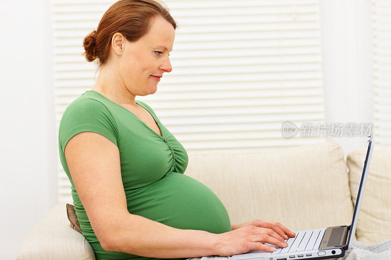 中年孕妇使用笔记本电脑
