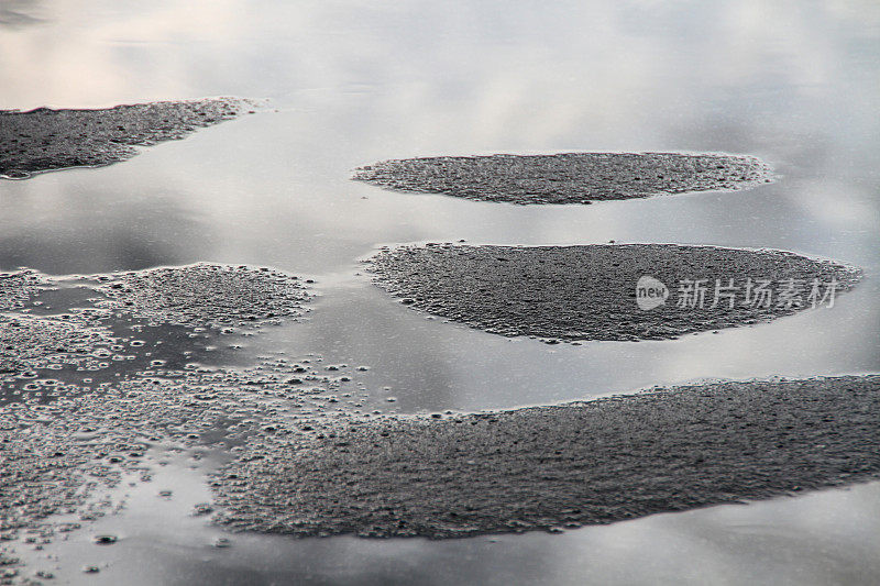 波浪形的沥青路面上有水坑