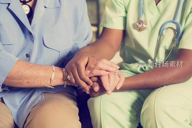 家庭护理护士牵着老年妇女的手。安慰。的好意。