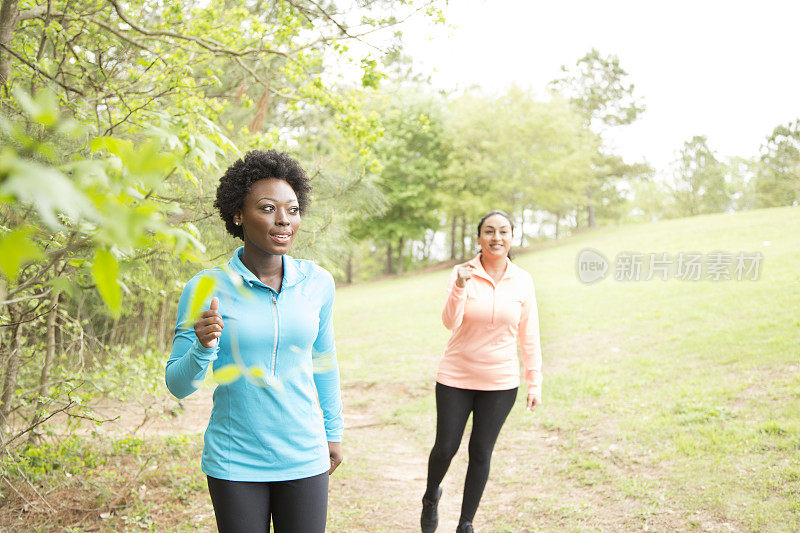 两个女性朋友在附近的公园里跑步。