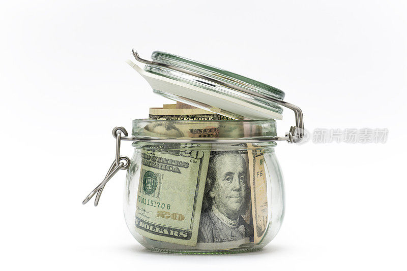 在白色背景上孤立的玻璃罐中的美元。存钱的概念。