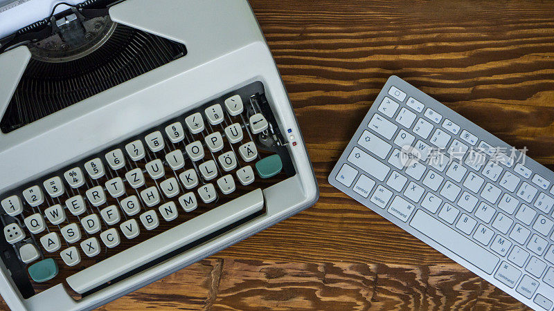 技术进步:老式打字机和现代电脑键盘。俯视图