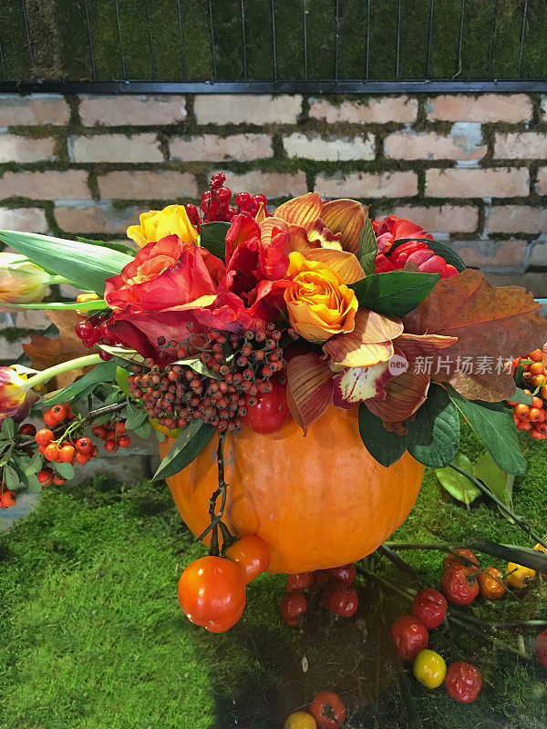 草桌上用南瓜和秋叶装饰着野花。秋天的背景。感恩节快乐背景