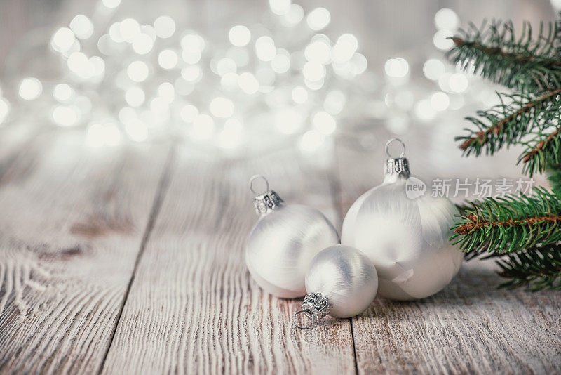 白色圣诞球在木材背景和散焦灯