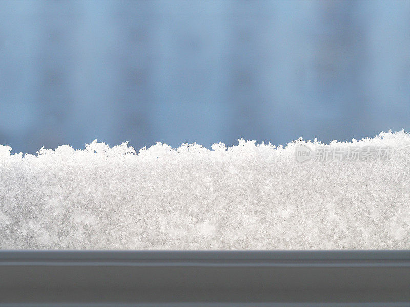 窗外的景色覆盖着雪花。雪覆盖的窗口。雪堆。冬天的背景。抽象的冬季背景。