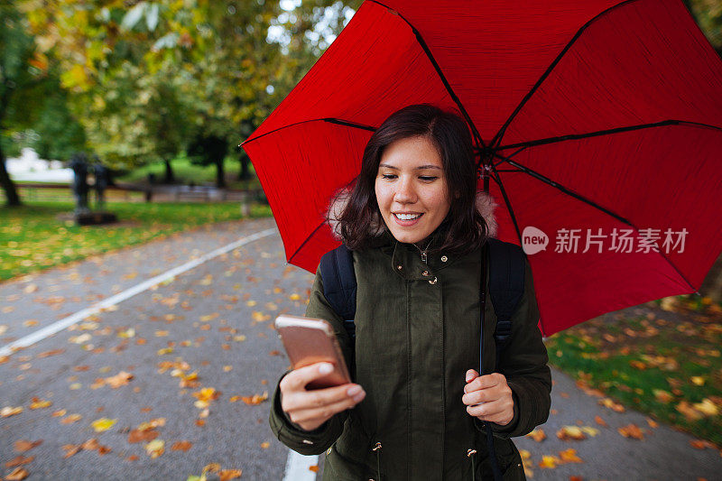 年轻女子与手机在雨天