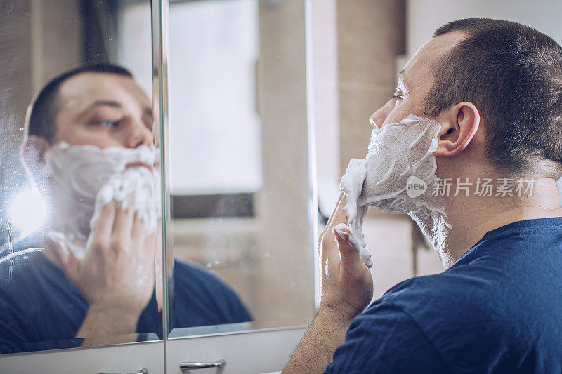 男人在浴室里擦剃须膏