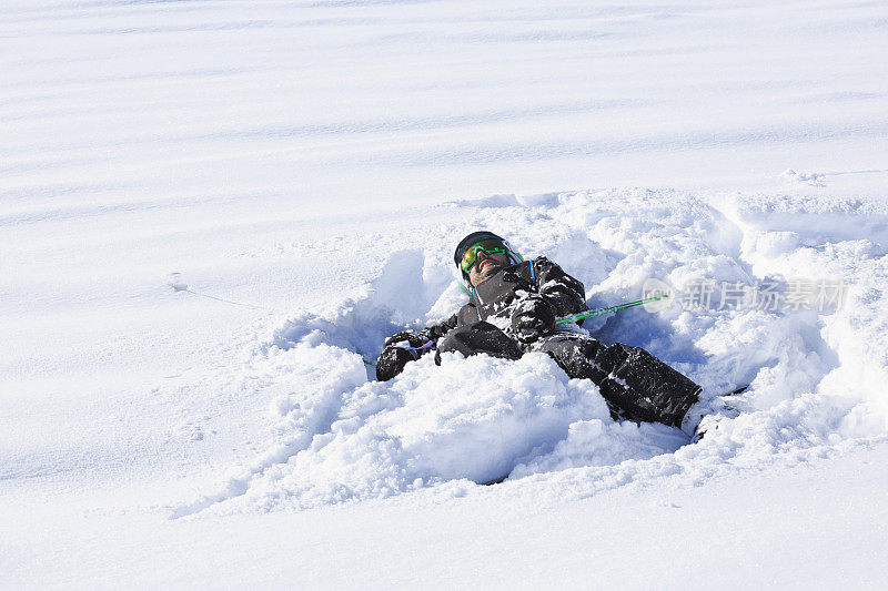男子滑雪者躺在粉雪中滑雪。在意大利的滑雪胜地Dolomites滑雪。