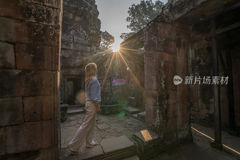 女游客漫游在古老的寺庙日落享受发现和旅游在亚洲，柬埔寨吴哥窟