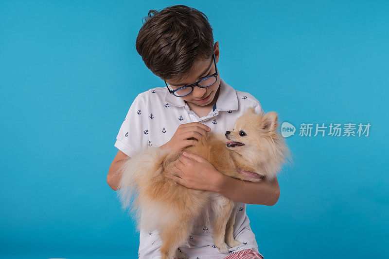 快乐的男孩和她的博美犬斯皮茨型狗