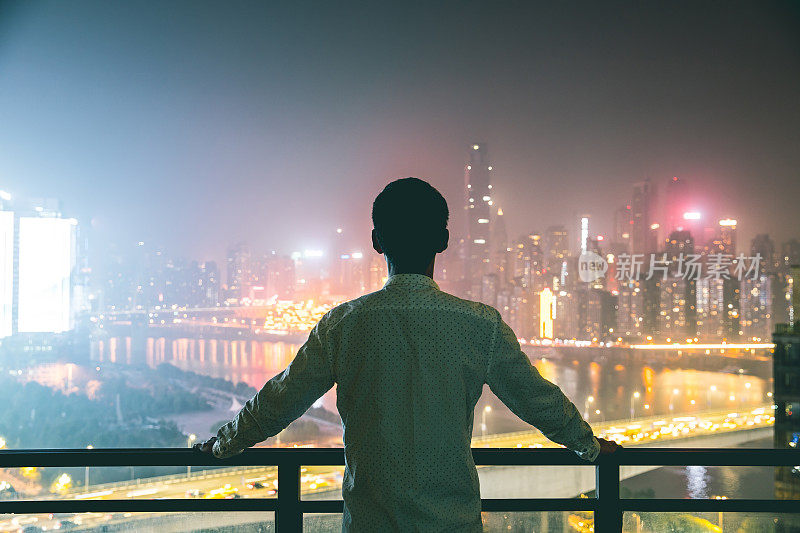 在重庆，一个年轻人看着城市的轮廓线