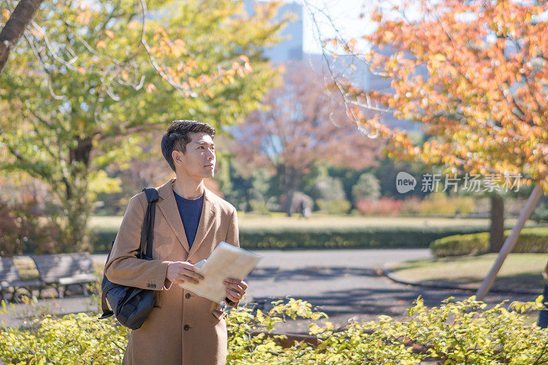 年轻的亚洲人日本人寻找旅游地点使用手机和花时间在亚洲旅行