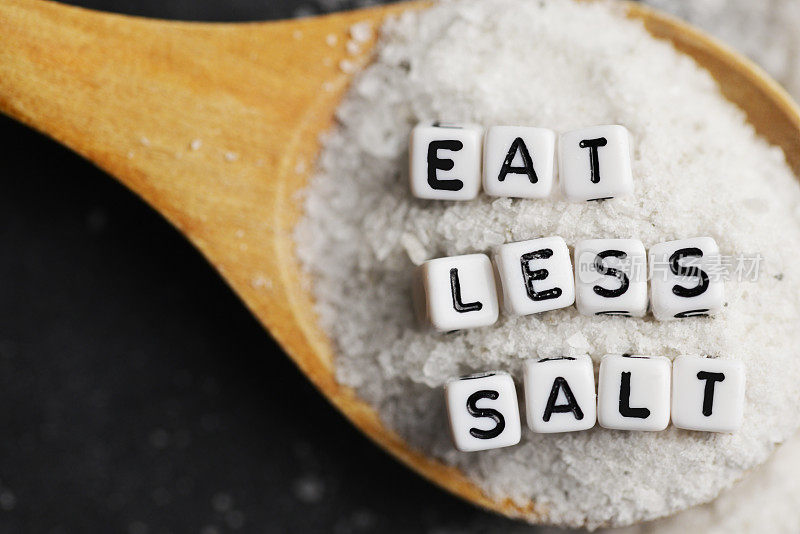 少吃盐，以降低血压或高血压的风险，撒盐的黑色背景