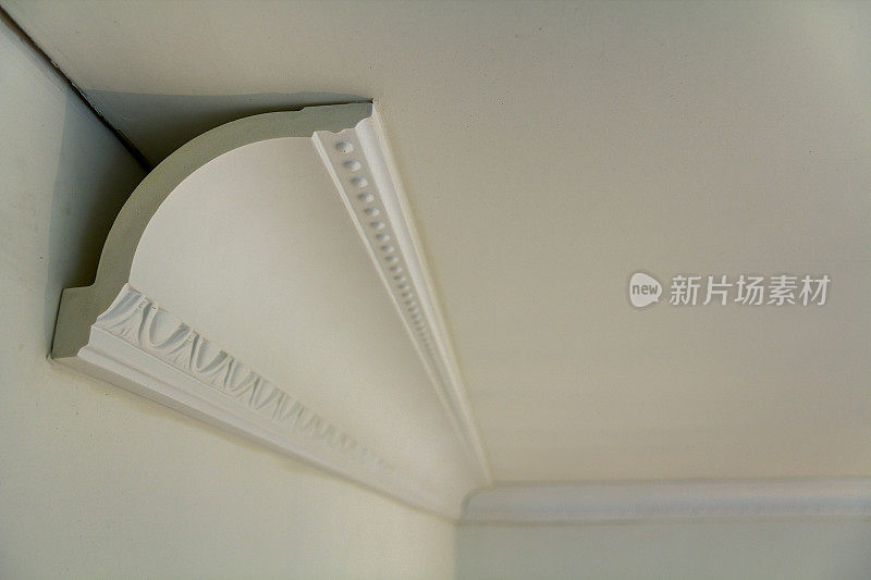 在室内装修改造中，用胶粘接在墙面和天花板上的装饰细部白色线条。
