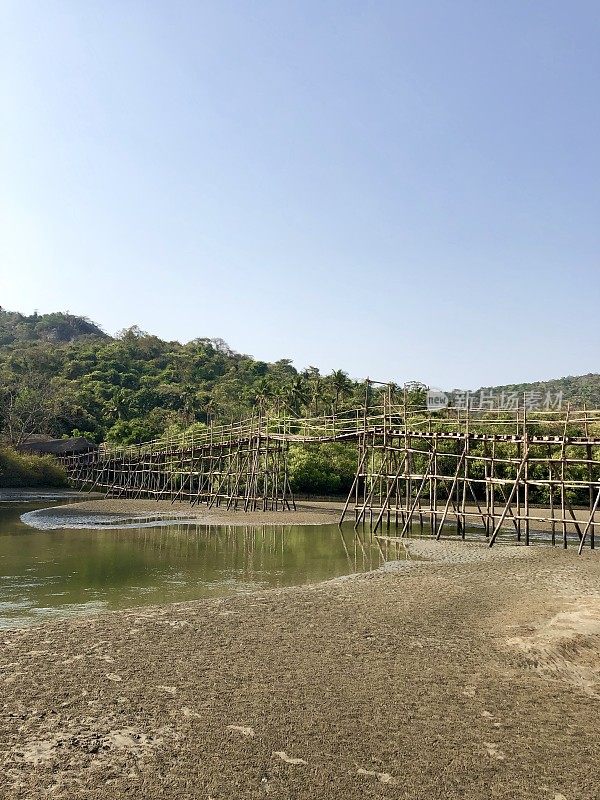 热带海滩岩石池泻湖椰子树，岩石，竹桥和金色的沙像天堂般的海滩度假照片，假日在果阿度假，Palolem海滩，南印度，海岸街道，天然岩石反射水面涟漪