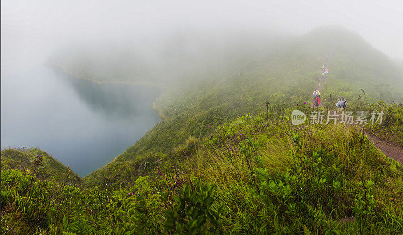 一群游客沿着厄瓜多尔雾天的Cuicocha湖徒步旅行