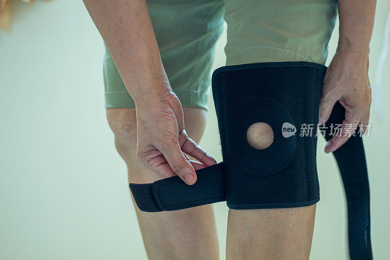 老年亚洲妇女膝盖受伤时，用膝盖支撑支架支撑腿