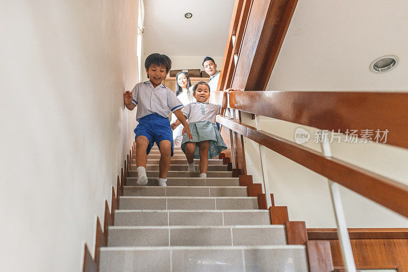 年轻的中国家庭在家里走楼梯