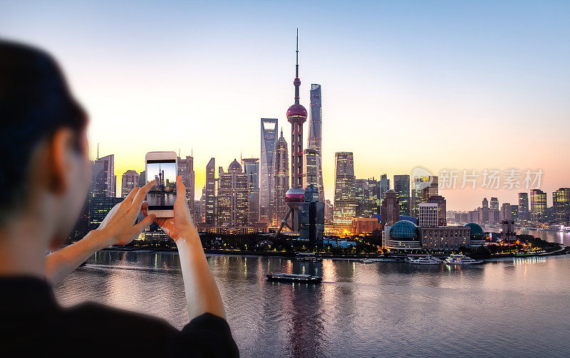 黎明时分，年轻的中国女子在上海拍摄东方明珠塔