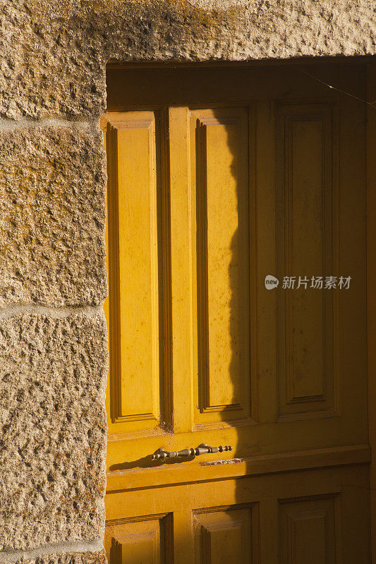 西班牙加利西亚，欧伦塞省，Allariz村，古老的黄色门关闭在传统的石头房子里。