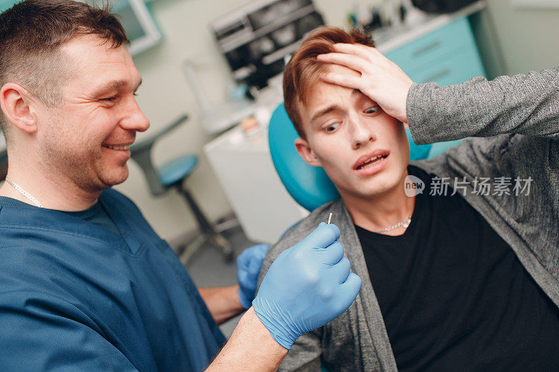 牙医。牙科医生向牙科诊所的病人展示植牙。吓唬病人。