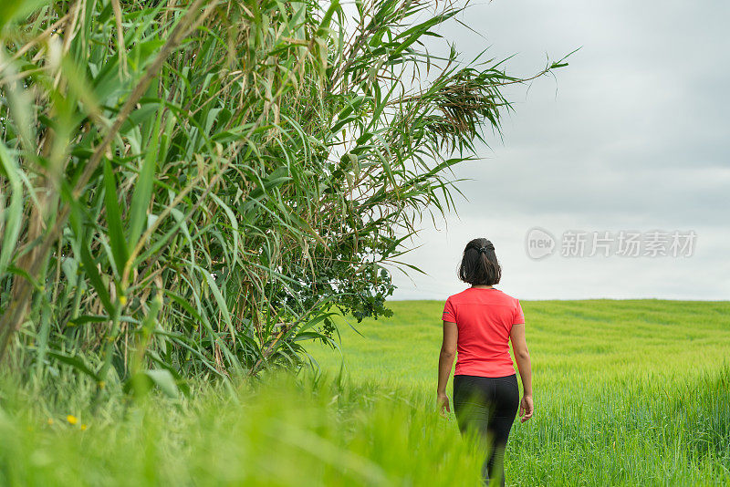 一名女子在封锁后走过绿色田野