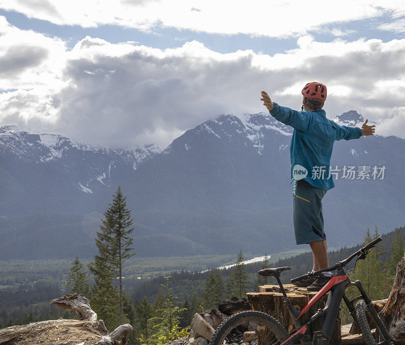 山地自行车站在树桩之上的山谷，山脉和森林
