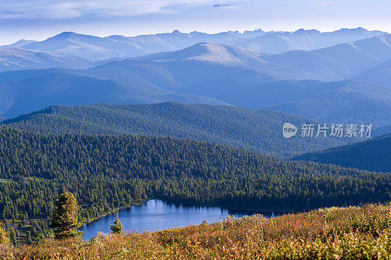 针叶林。西伯利亚。湖泊和山脉在黎明与美丽的云彩