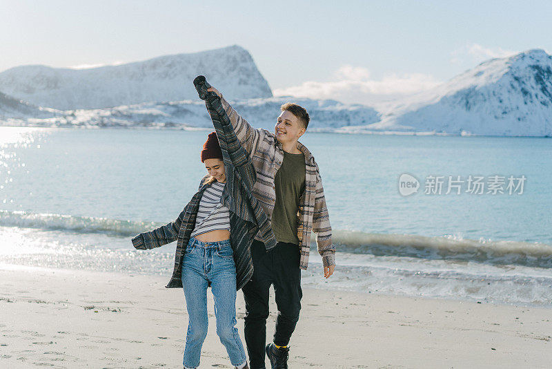 女人和男人有乐趣的海边在冬天罗浮敦岛